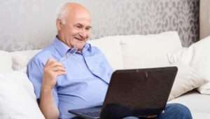 older man using his laptop to research funerals
