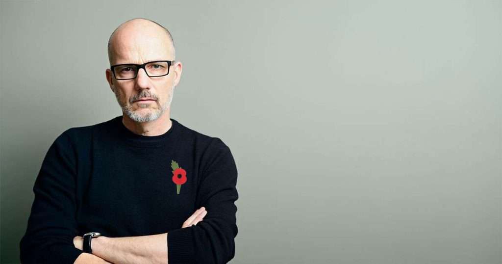 man serious arms folded with poppy