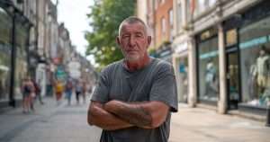 unhappy man has arms folded on UK high street