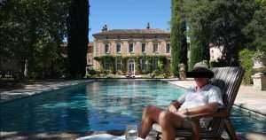 Wealth man next to mansion and pool