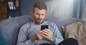 David Beckham looking at his phone.