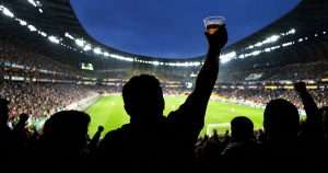 Football fan with beer in the stands