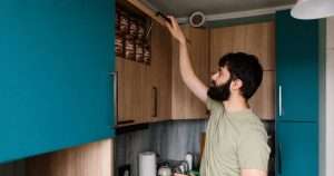 Man opening cupboard full of gravy